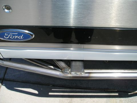 1993 Ford Bronco - Ford emblem visible on a brushed metal panel above a custom steel tube bumper, likely a rear modification.
