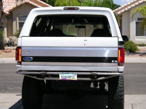 1993 Ford Bronco - Rear view of a white 1993 Ford Bronco a custom metal bumper and a personalized license plate.