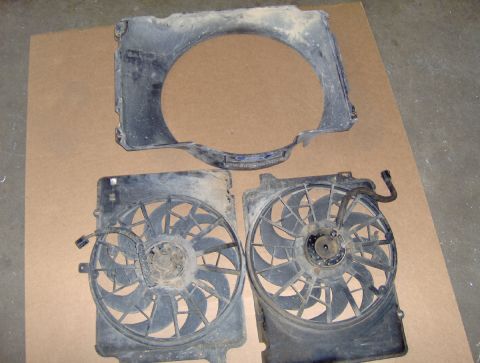 1978 Ford Bronco - Two electric fans and a shroud are laid out on a cardboard surface.