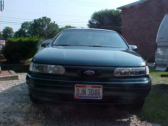 Front view of dark green Ford Taurus on gravel, Ohio plate DJN 3046