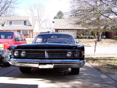 1966 Mercury Monterey - A black 1966 Mercury Monterey is parked in a suburban driveway, showing its distinctive grille and headlights.