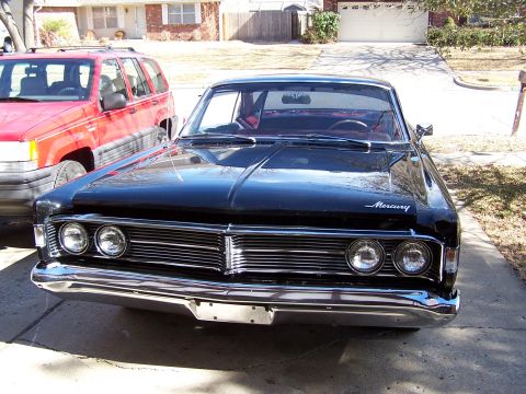 1966 Mercury Monterey - Frontal view of a black 1966 Mercury Monterey sedan with a chrome grille and dual headlights.
