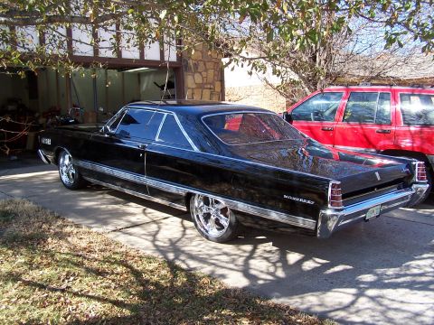1966 Mercury Monterey - Black 1966 Mercury Monterey coupe with custom wheels parked outside a garage.