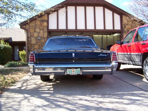 1966 Mercury Monterey - The rear of a black 1966 Mercury Monterey is visible, parked in front of a garage.