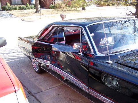 1966 Mercury Monterey - A black 1966 Mercury Monterey coupe is parked on a driveway, showing its distinctive body lines and chrome accents.