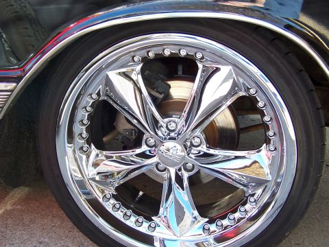 1966 Mercury Monterey - Close-up of a shiny chrome custom wheel and tire, with brake components visible behind the spokes.