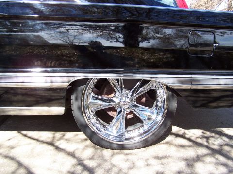1966 Mercury Monterey - The side view of a black 1966 Mercury Monterey shows its chrome wheel and trim.