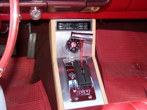 1966 Mercury Monterey - The interior of a 1966 Mercury Monterey shows a red dashboard and floor mats, with a chrome shifter and RPM gauge as focal points.