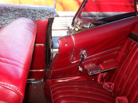 1966 Mercury Monterey - Interior view of a red 1966 Mercury Monterey convertible, highlighting the seats and door panel details.