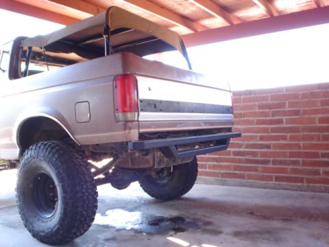 1989 Ford Bronco - This lifted Ford Bronco is shown from the rear, with its soft top canopy partially retracted.