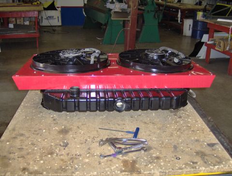 1978 Ford Bronco - A radiator and dual fan assembly sits on a workbench, with tools nearby.