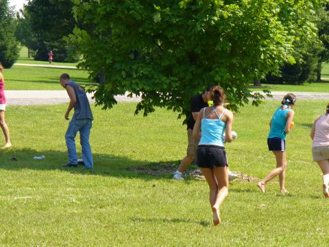 1991 Ford Probe - Several people are enjoying a sunny day in a park, with some running and others standing.