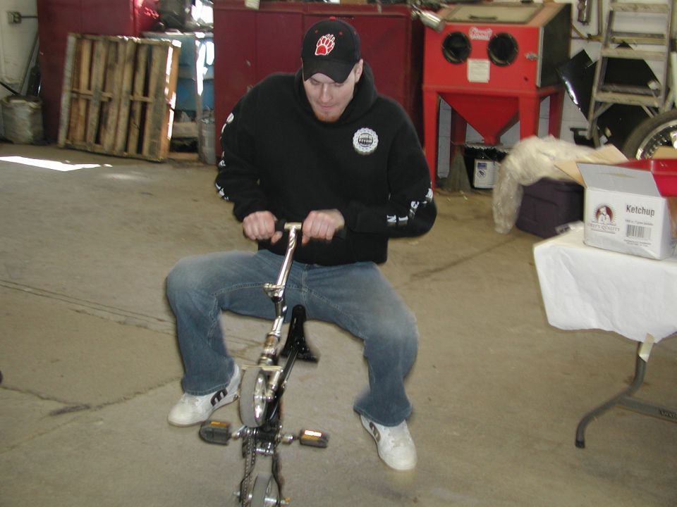 Man riding a small bicycle indoors