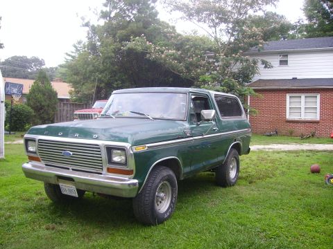 1978 Ford Bronco - 1978 Ford Bronco in a yard, showing its front grille and side profile.