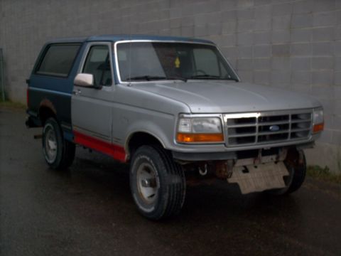 1990 Ford Bronco - This Ford Bronco has a two-tone paint job with mismatched panels and a missing front bumper.
