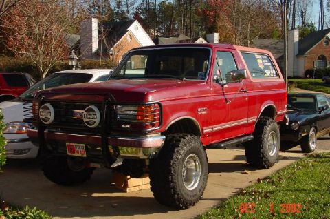 1991 Ford Bronco - This lifted Ford Bronco features large off-road tires and Hella auxiliary lights on its front bumper.