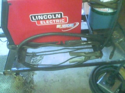 1989 Ford Bronco - Welding equipment, including a Lincoln Electric machine and a gas cylinder, is shown in this close-up view.