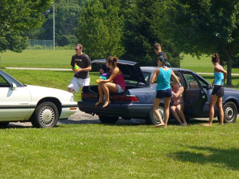 1991 Ford Probe - People gathered around two cars on a sunny day.