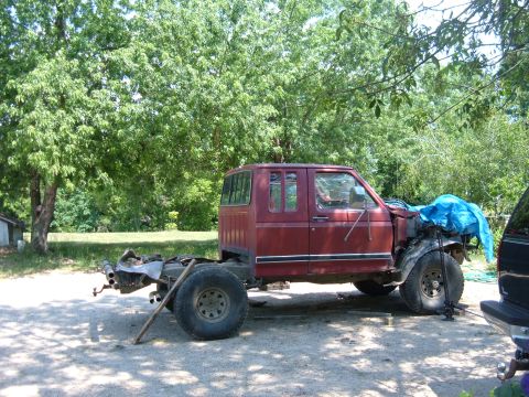 1985 Ford F-150 - This truck appears to be undergoing repairs or a rebuild, with its front end damaged and covered.