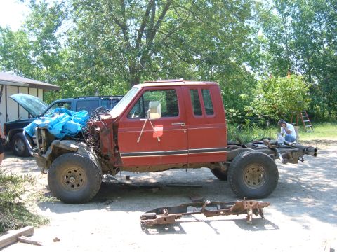 1985 Ford F-150 - This red truck chassis is missing its front end and appears to be undergoing modifications.
