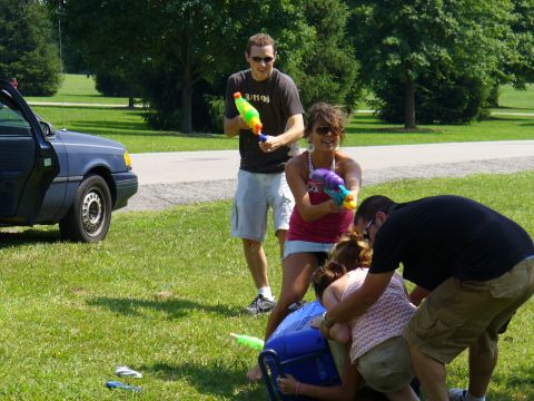 1991 Ford Probe - A group of friends enjoys a water gun fight on a sunny day in a park.