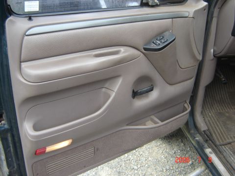 1993 Ford Bronco - Interior door panel of a 1993 Ford Bronco, showing power window controls and a storage compartment.