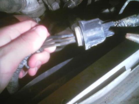1989 Ford Bronco - Close-up of a hand holding an electrical connector with wires.