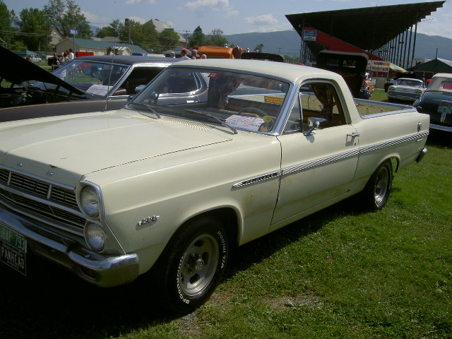 1967 Ford Ranchero parked on grass with other vehicles in background