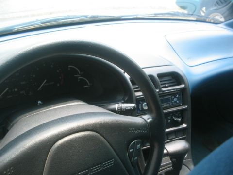 1994 Ford Probe - The interior of a car, the dashboard, steering wheel, and center console with a radio.