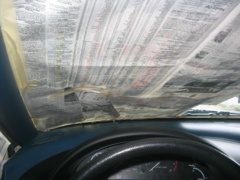 1994 Ford Probe - Newspaper covers the interior of a car, obscuring the windshield and dashboard.