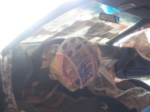 1994 Ford Probe - Newspapers cover the interior of a car, obscuring the dashboard and seats.