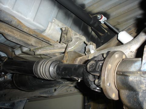 1996 Ford Bronco - Custom rear shock mount installation on a vehicle's rear axle and driveshaft.