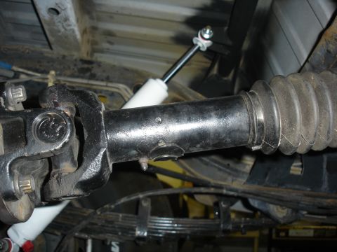 1996 Ford Bronco - Close-up view of the driveshaft and suspension system of a vehicle, showing various mechanical components.