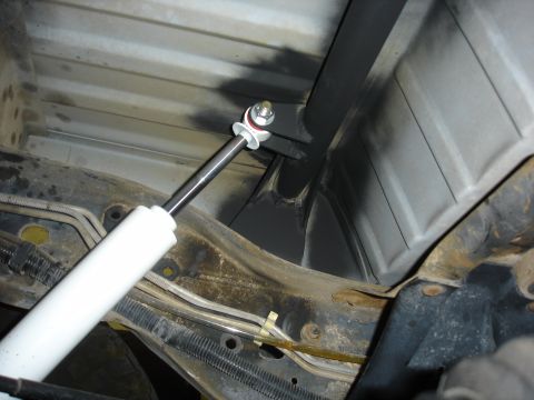 1996 Ford Bronco - Custom rear shock mount bracket with white shock absorber attached to rusty frame.