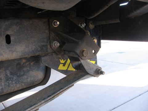 1990 Ford Bronco - Close-up view of a suspension component with a yellow logo a crown.