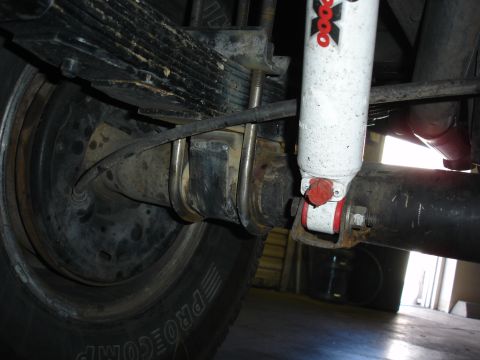 1996 Ford Bronco - This image shows the rear axle and suspension components of a vehicle, including leaf springs and a shock absorber.