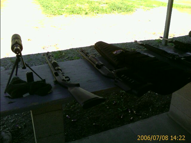 Spotting scope and shotguns on a table at a shooting range
