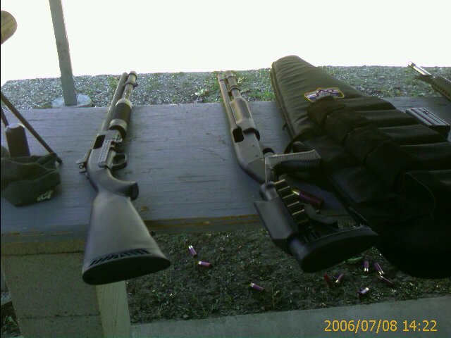Two shotguns and a gun bag on a table with scattered shells on the ground