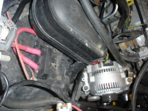 1996 Ford Bronco - Close-up view of an alternator and associated wiring in a vehicle's engine compartment.