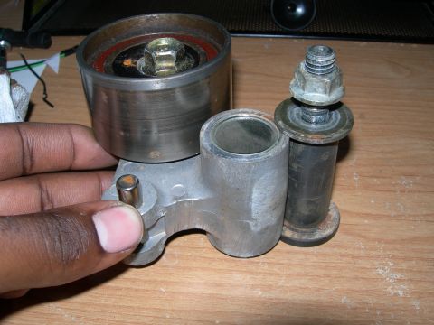 1992 Ford Taurus - A belt tensioner pulley assembly is shown, with a bolt and washer visible.