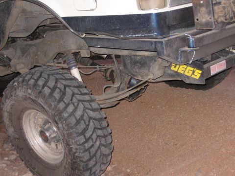 1990 Ford Bronco - Close-up view of the rear suspension and tire of an off-road vehicle, a JEG'S sticker on the bumper.