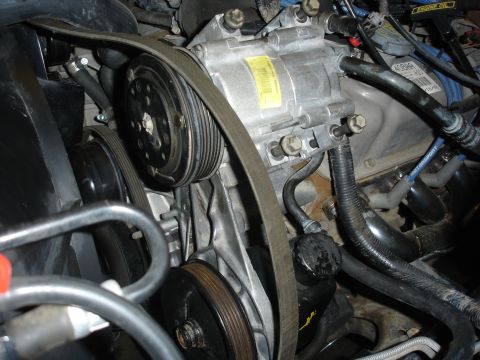 1996 Ford Bronco - Close-up view of the engine bay, focusing on the serpentine belt and AC compressor system.