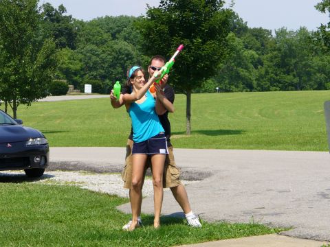 1991 Ford Probe - Couple having fun with water guns outdoors, with a car visible in the background.