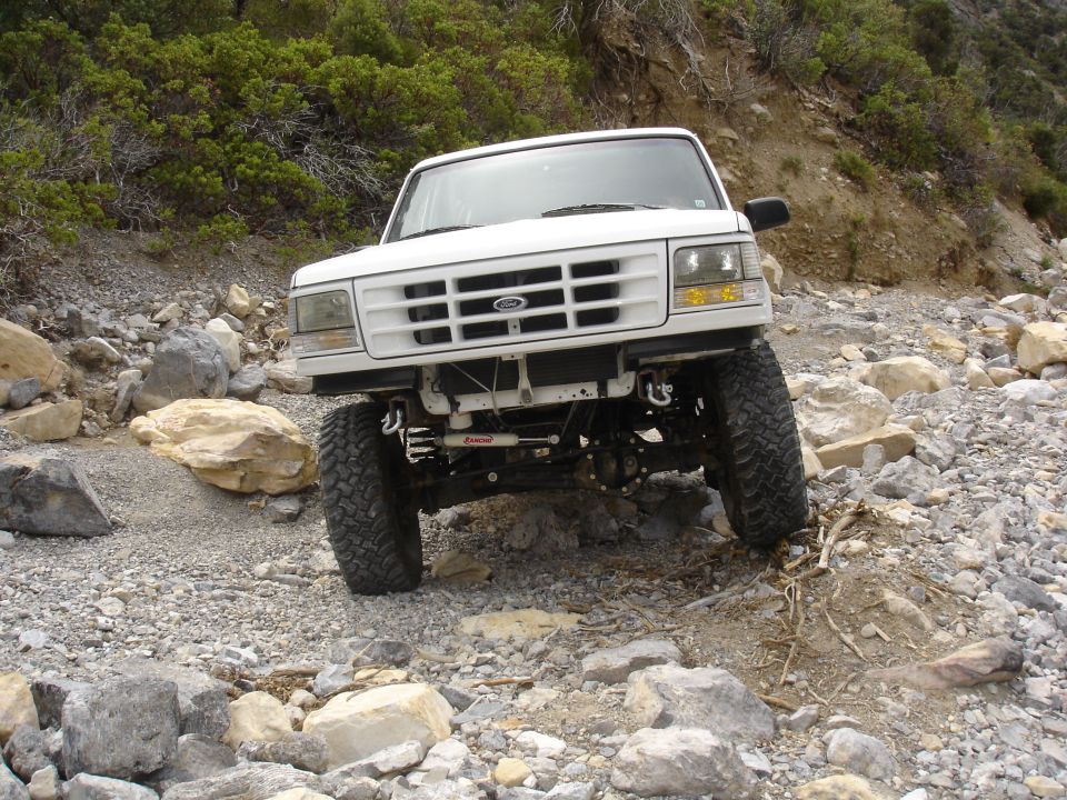 White 1996 Ford Bronco navigating a rocky off-road path