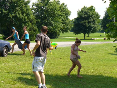 1991 Ford Probe - A group of people are enjoying a sunny day in the park with water guns.