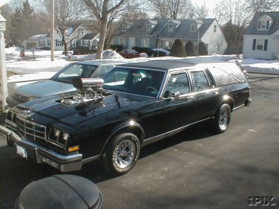 1977 Ford Mustang II - This custom hearse features a large blower protruding from the hood, parked in a snowy residential area.