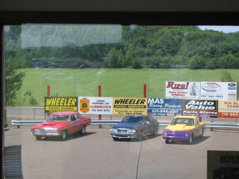 1989 Ford Mustang - A dark gray 1989 Ford Mustang is parked on a drag strip alongside two other vehicles.