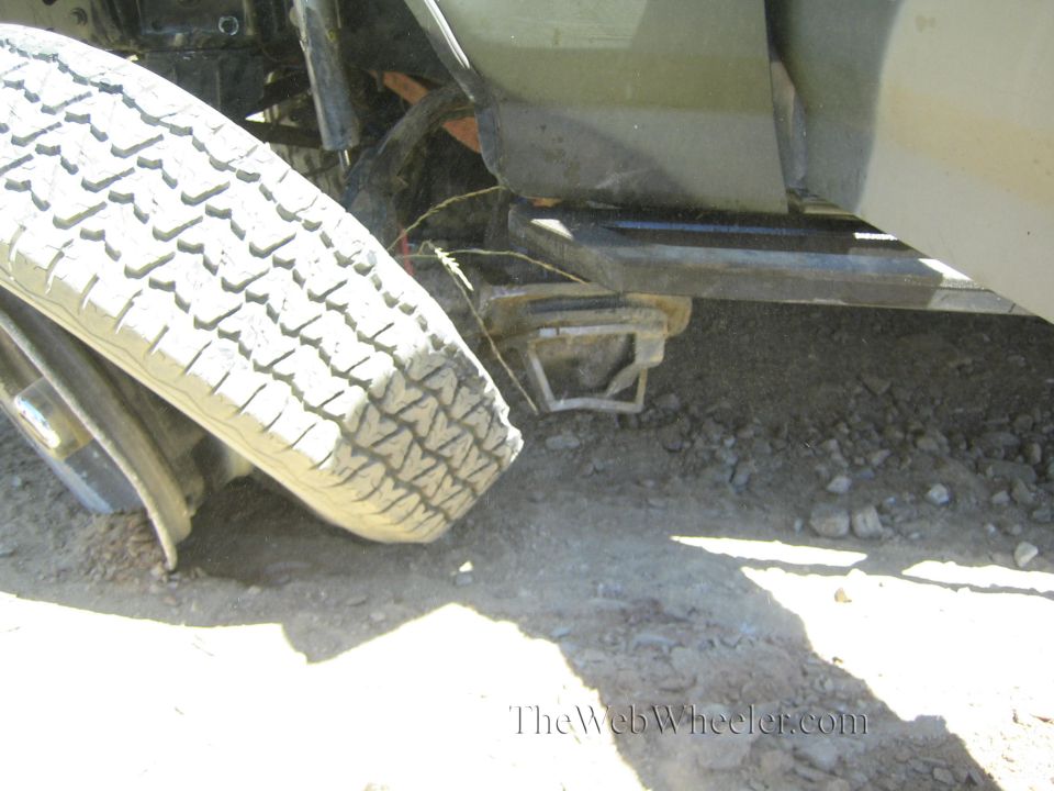 Tire folded under truck near bent step bar and tow hitch