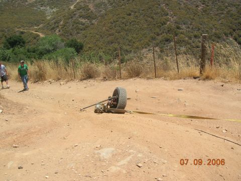 1985 Ford Bronco - An axle and wheel assembly is seen on a dirt road, possibly after a recovery operation.