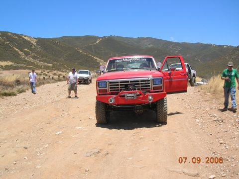 1985 Ford Bronco - This red 1986 Ford F-150 features a prominent winch and custom bumper, with a website visible on the windshield.